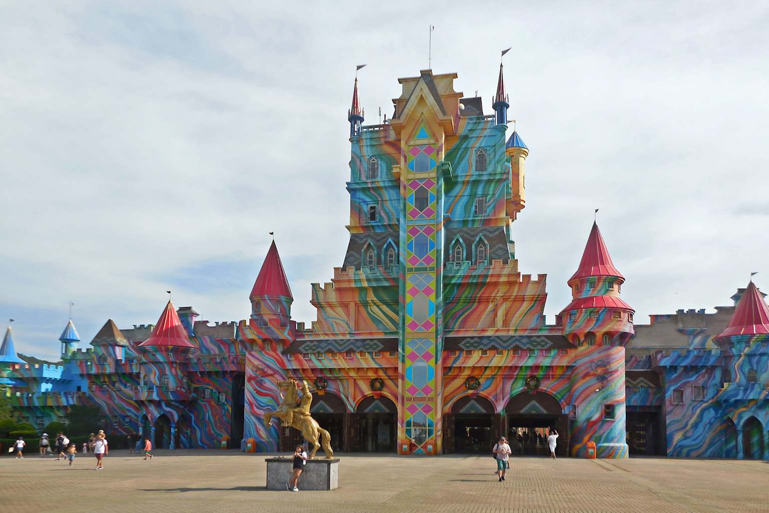 Entrance of Beto Carrero World theme park in Santa Catarina, Brazil, featuring a colorful castle facade and a golden horse statue.
