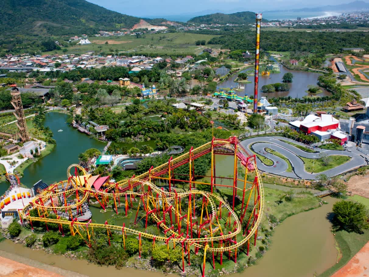 Aerial view of Beto Carrero World theme park in Santa Catarina, Brazil, showcasing its roller coaster, go-kart track, and lush surroundings.