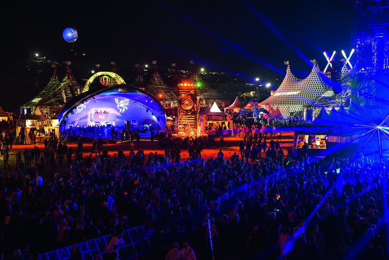 Nighttime scene at SonneMondSterne Festival showcasing illuminated stages and a crowd of festival-goers in Saalburg, Germany