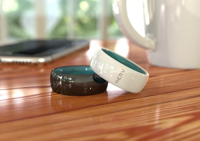Two Kerv contactless payment rings placed on a wooden table, illustrating wearable payment technology