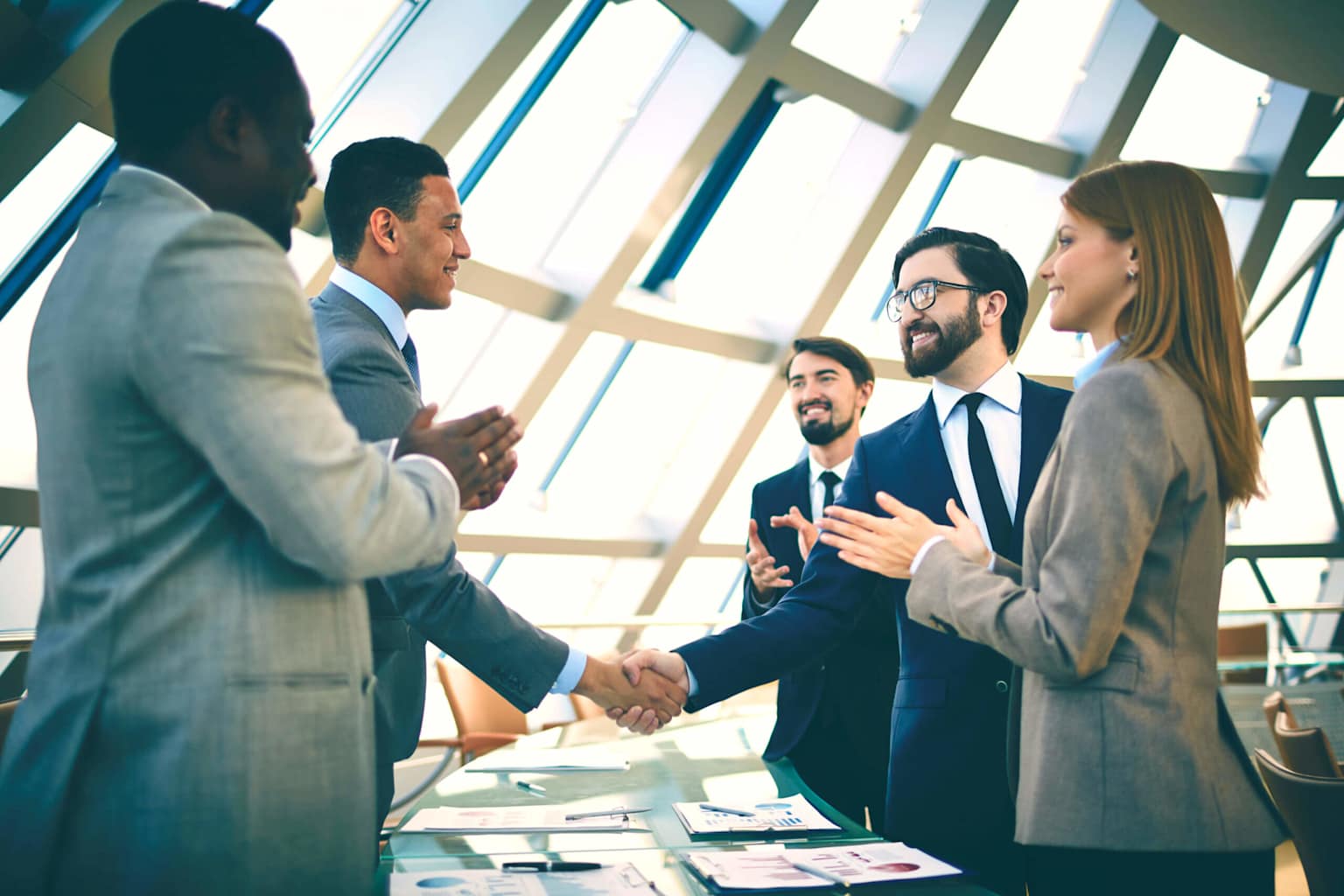 Business professionals shaking hands to signify a successful partnership in a collaborative office setting