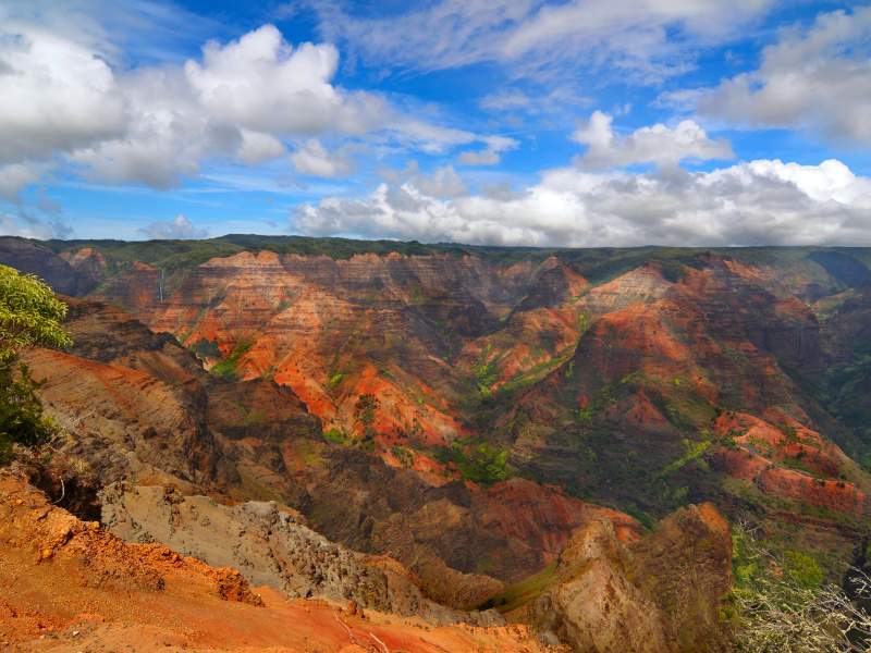 Waimea Canyon on Kauai showcases vibrant red rock formations and lush valleys known as the Grand Canyon of the Pacific