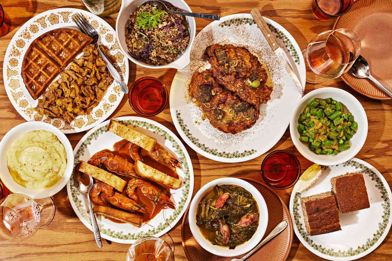A vibrant array of soul food dishes including fried chicken, waffles, prawns, and greens served on patterned plates, showcasing Oakland's diverse and affordable food scene