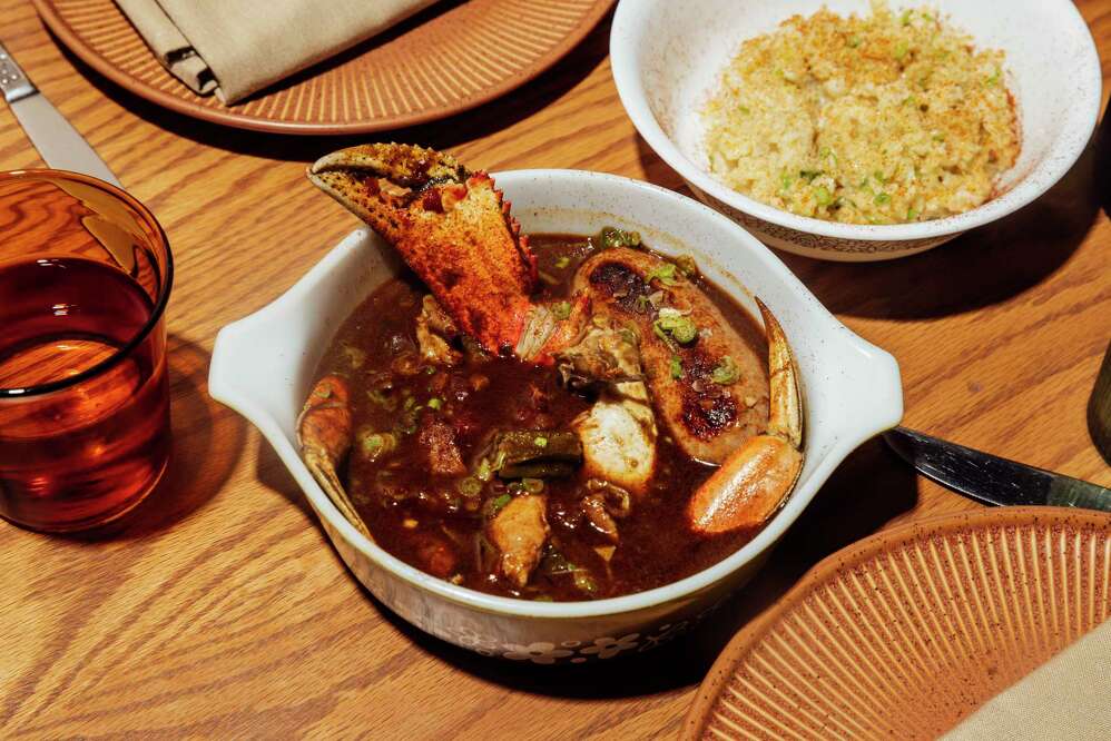 A bowl of crab stew with a side of seasoned rice showcasing Oakland's diverse food scene