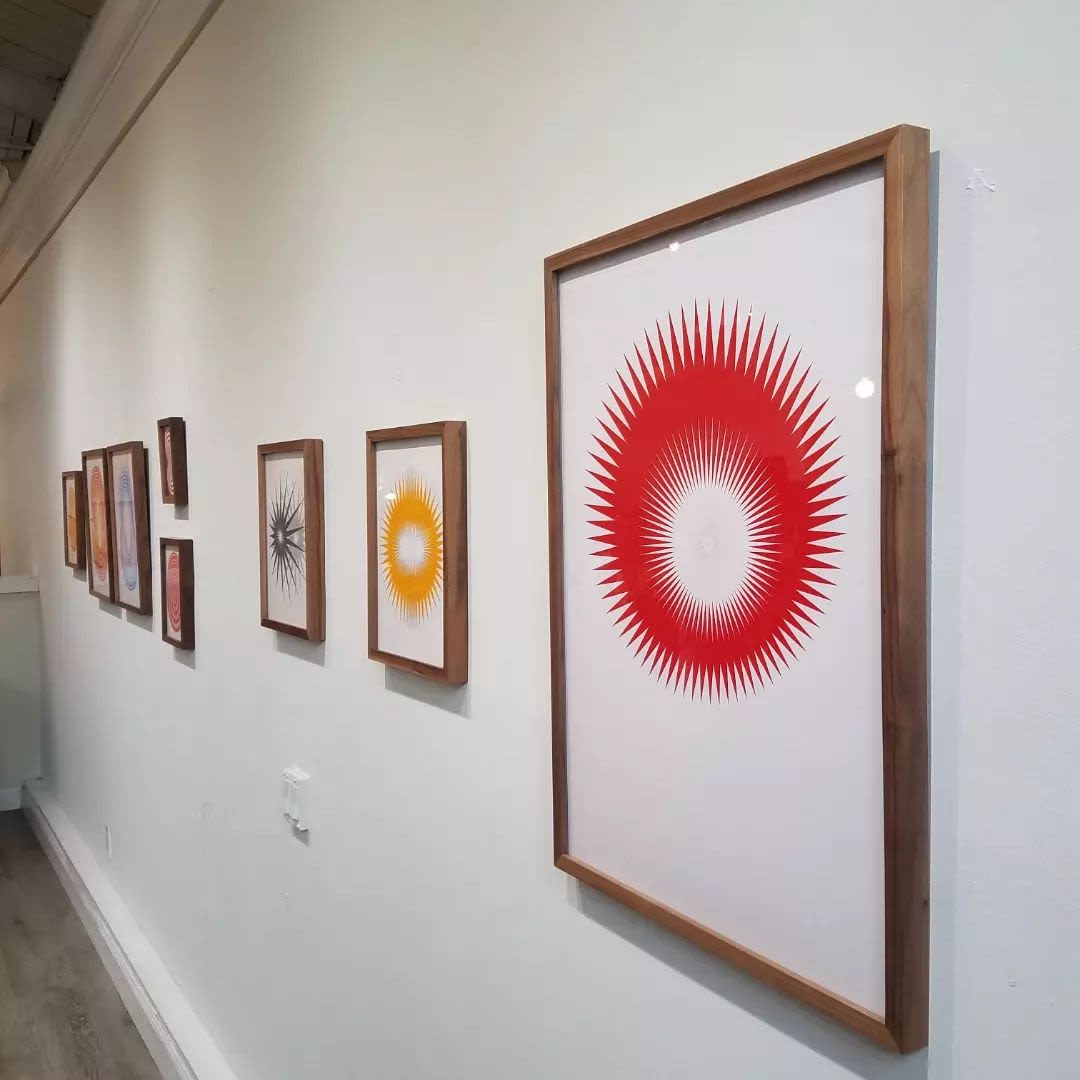 Abstract starburst artworks displayed in a gallery during Oakland's art walk event