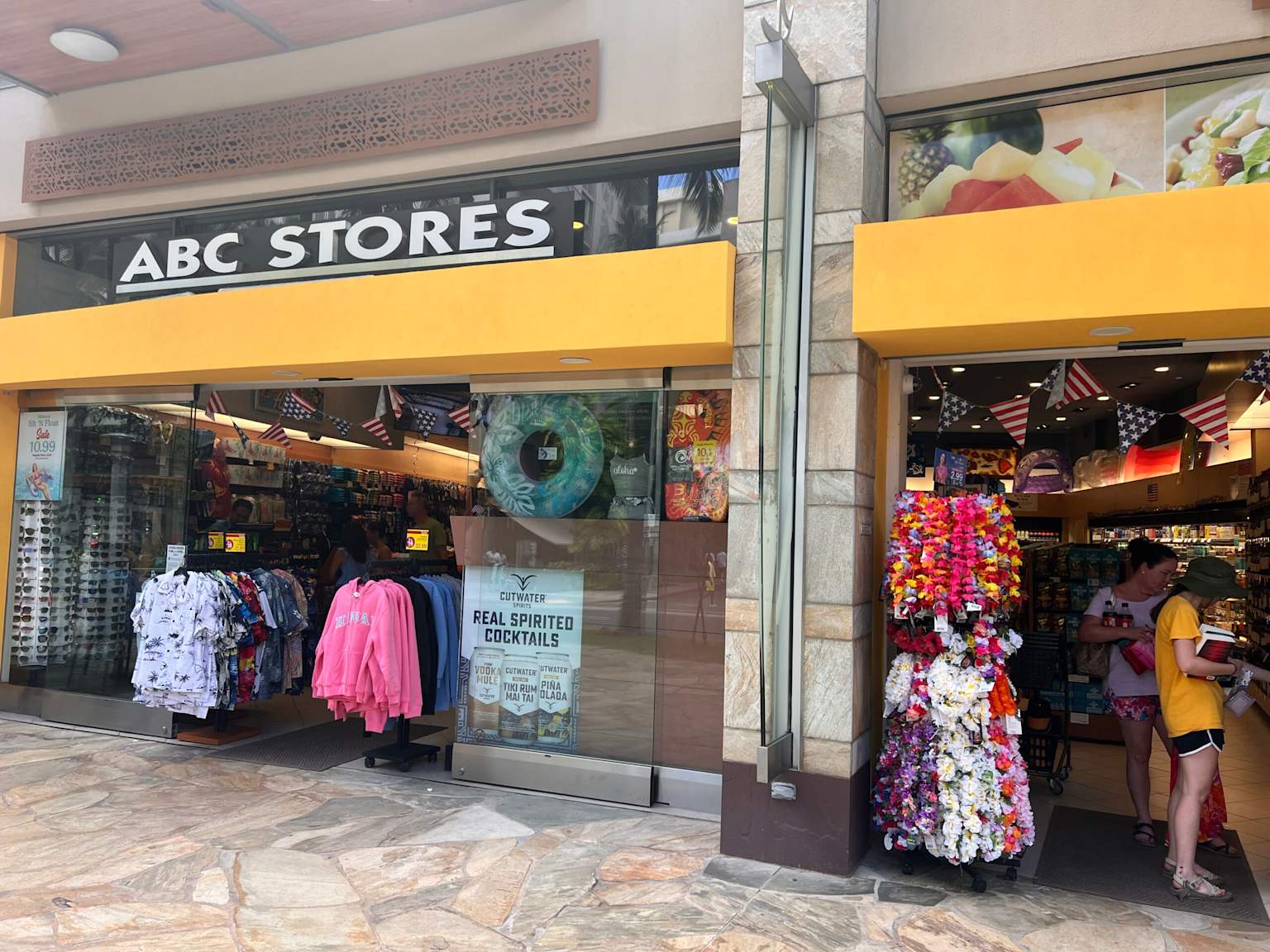 ABC Stores in Hawaii with colorful leis and tourist souvenirs displayed outside and inside the store