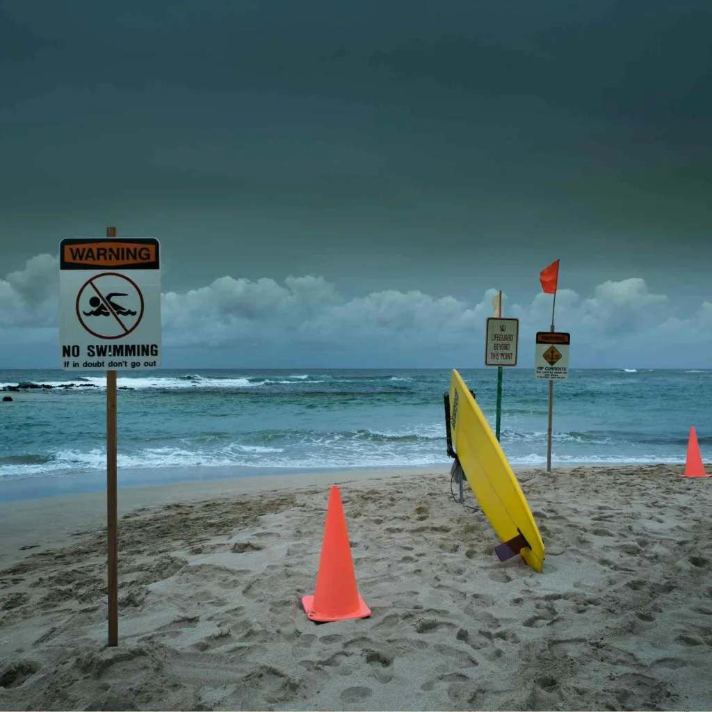 Warning signs on a Hawaii beach alert visitors to no swimming zones and ocean dangers like rip currents