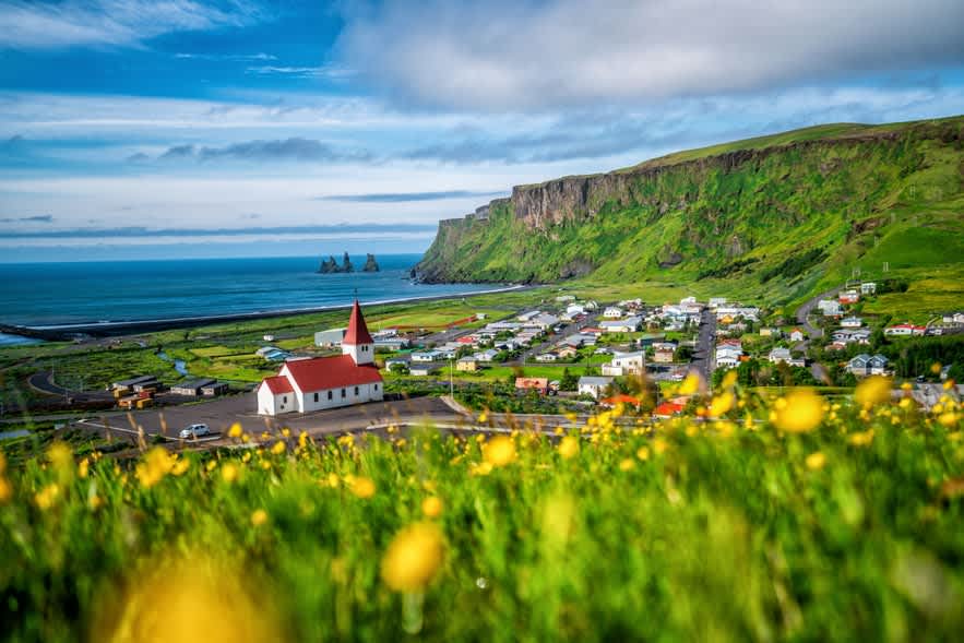 Vik Church with red roof and white walls overlooking coastal village