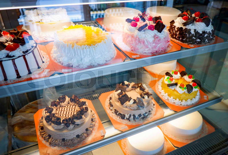 Variety of decorated cakes in bakery showcase