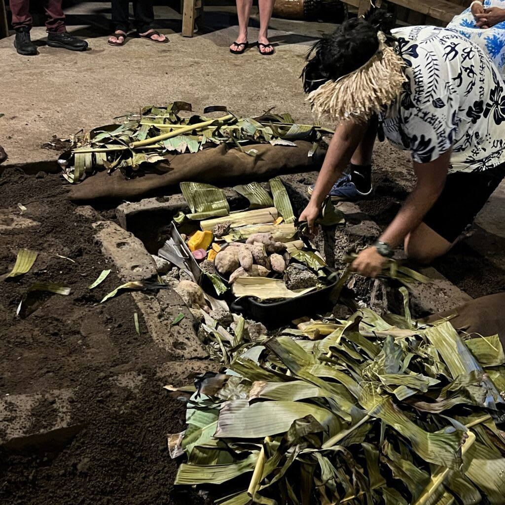 A cultural ceremony showing the traditional Rapa Nui umu earth oven cooking with local root vegetables wrapped in leaves on Easter Island