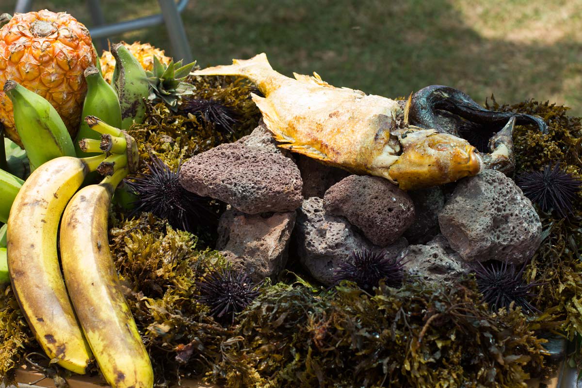 Traditional Rapa Nui umu cooking with volcanic stones, sea urchins, pineapples, and bananas as part of a cultural feast on Easter Island