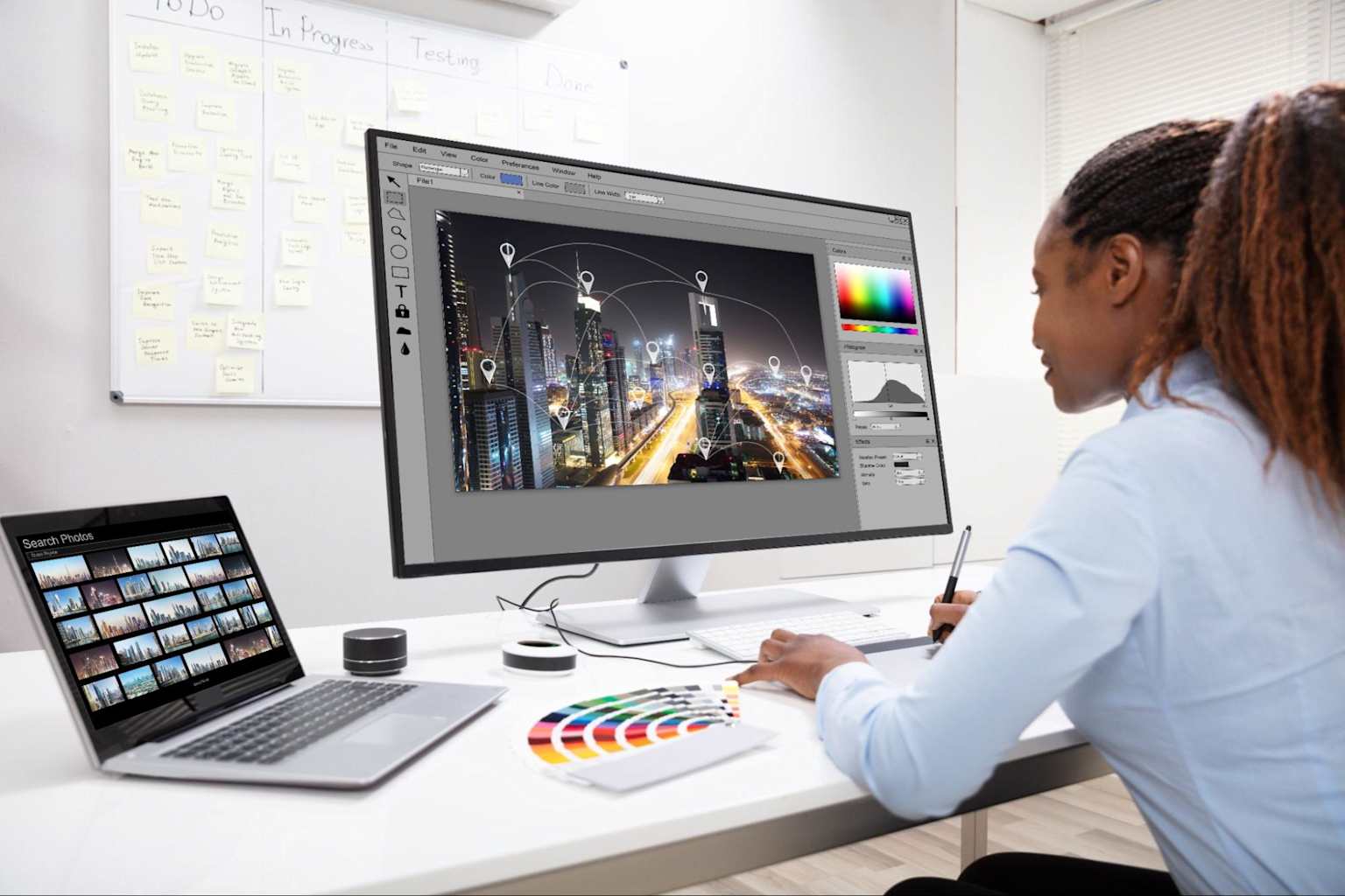 A graphic designer working with digital design software and tools in a professional workspace showcasing an organized project workflow