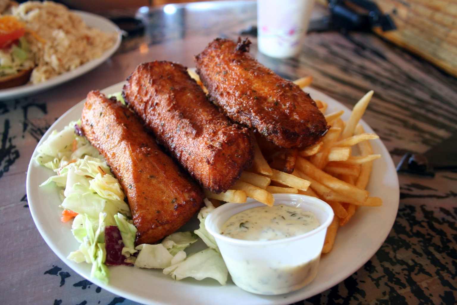 A classic plate of fried fish, French fries, cole slaw, and tartar sauce served at Paia Fish Market, a popular Maui seafood spot favored by locals