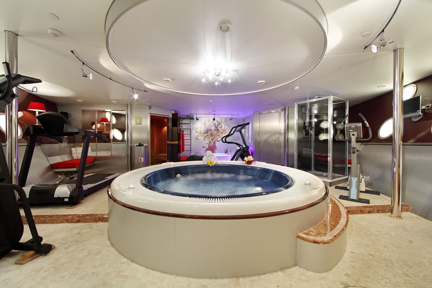 Luxury yacht interior featuring a jacuzzi and gym equipment, combining spa and fitness amenities in a stylish setting