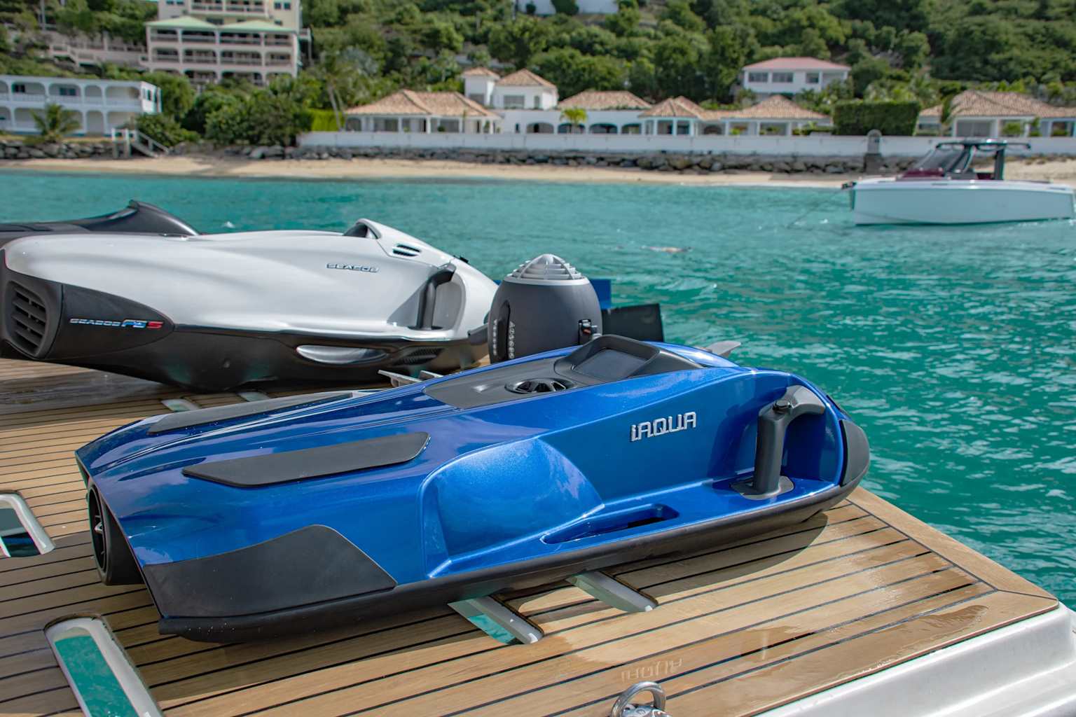 Seabob F5 and iAQUA water toys on a yacht deck by a tropical coastline, showcasing water toys often available on luxury yacht charters