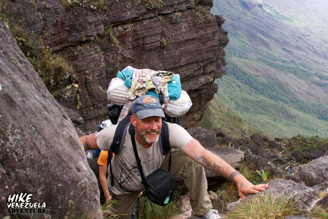 Hiker ascending the rocky terrain of Mount Roraima during a challenging trekking expedition in Venezuela