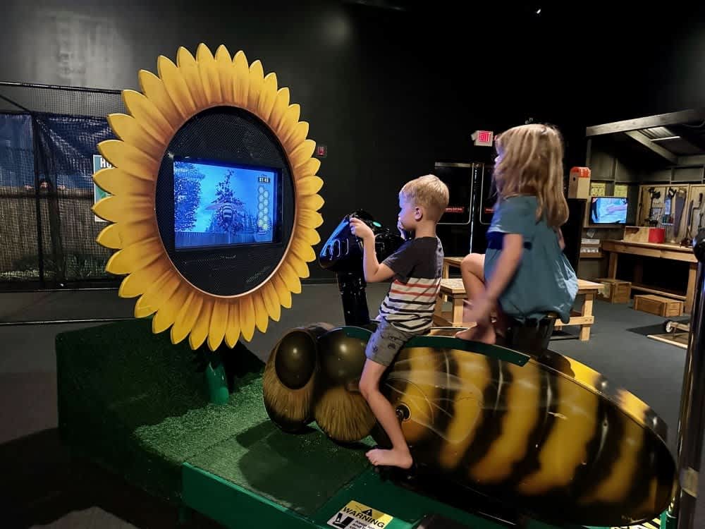 Children engaging with an interactive bee exhibit at Bishop Museum showcasing educational activities for families in Hawaii