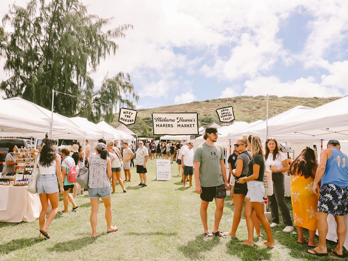 Shoppers exploring the Malama Hawaii Makers Market featuring local artisans and handmade goods in a vibrant outdoor setting