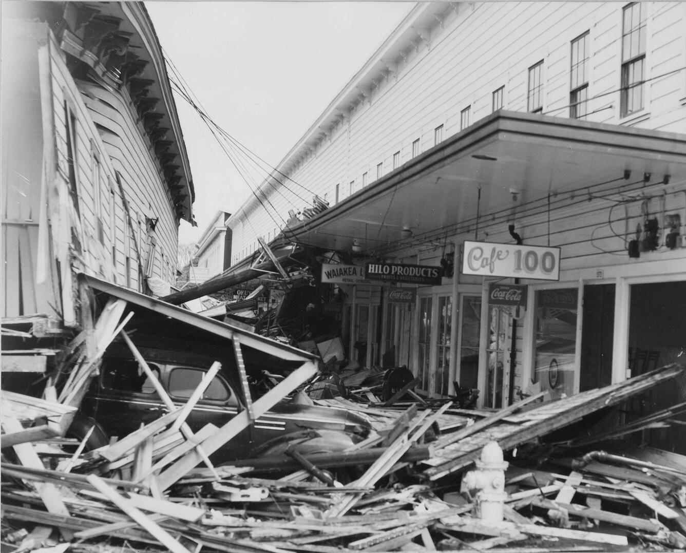 Historic aftermath of the 1946 Hilo tsunami showing widespread destruction and collapsed buildings along a commercial street