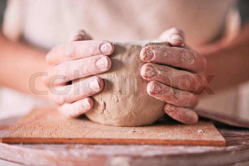 Hands shaping clay