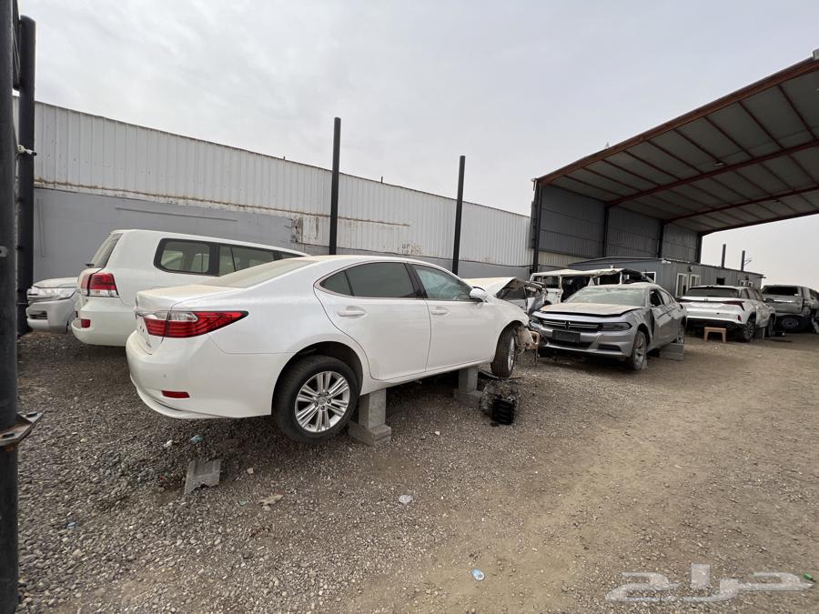 A car salvage yard in Buraidah featuring damaged vehicles and dismantled cars for spare parts
