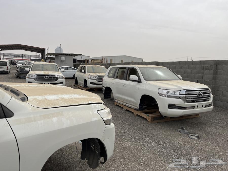 White Toyota SUVs in a dusty scrapyard in Buraydah, representing typical vehicles found in local car chop shops