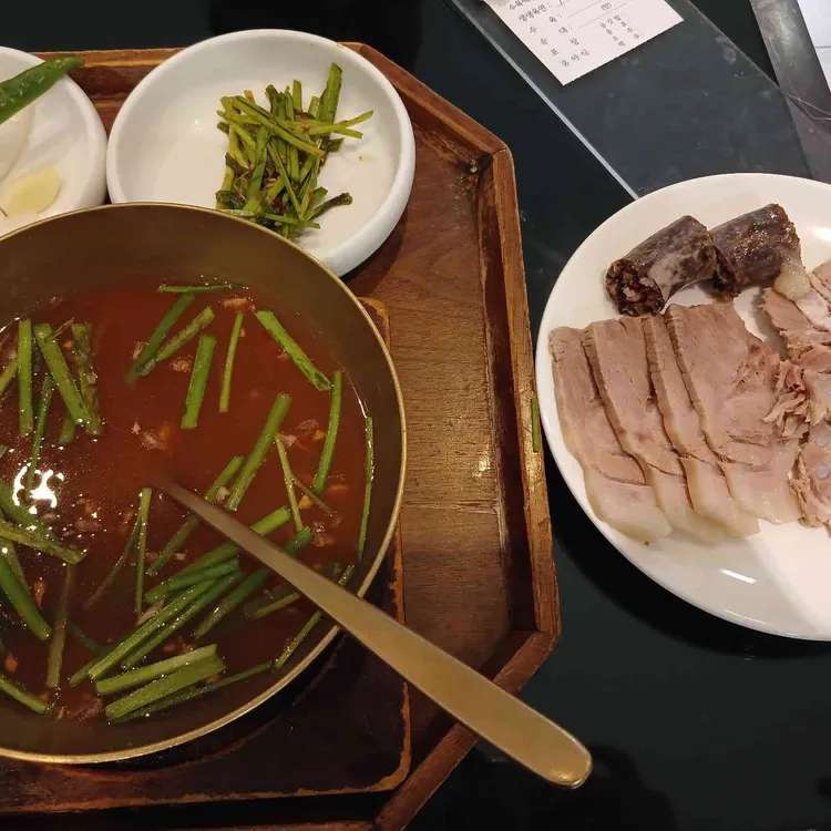 A Korean pork soup meal with broth, pork slices, and blood sausage from a Busan Station area restaurant.
