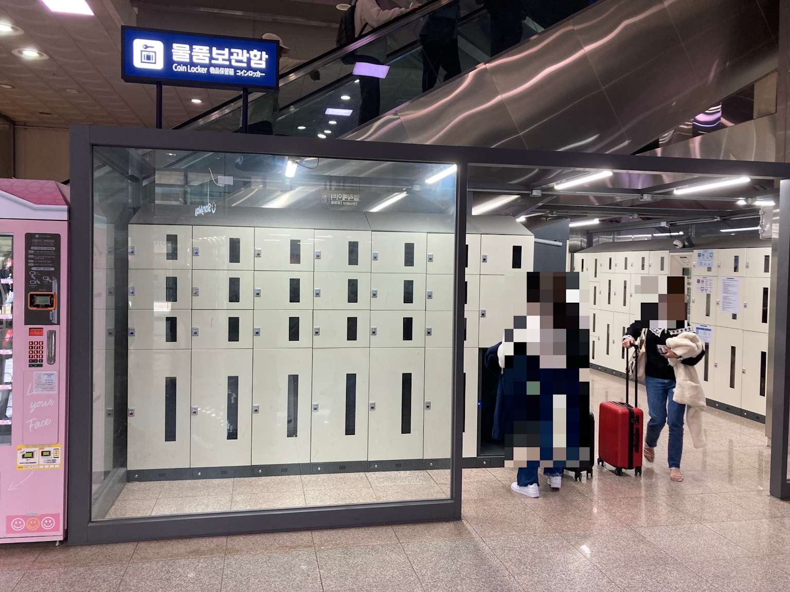Coin locker area with multiple luggage lockers near an escalator inside Busan Station.
