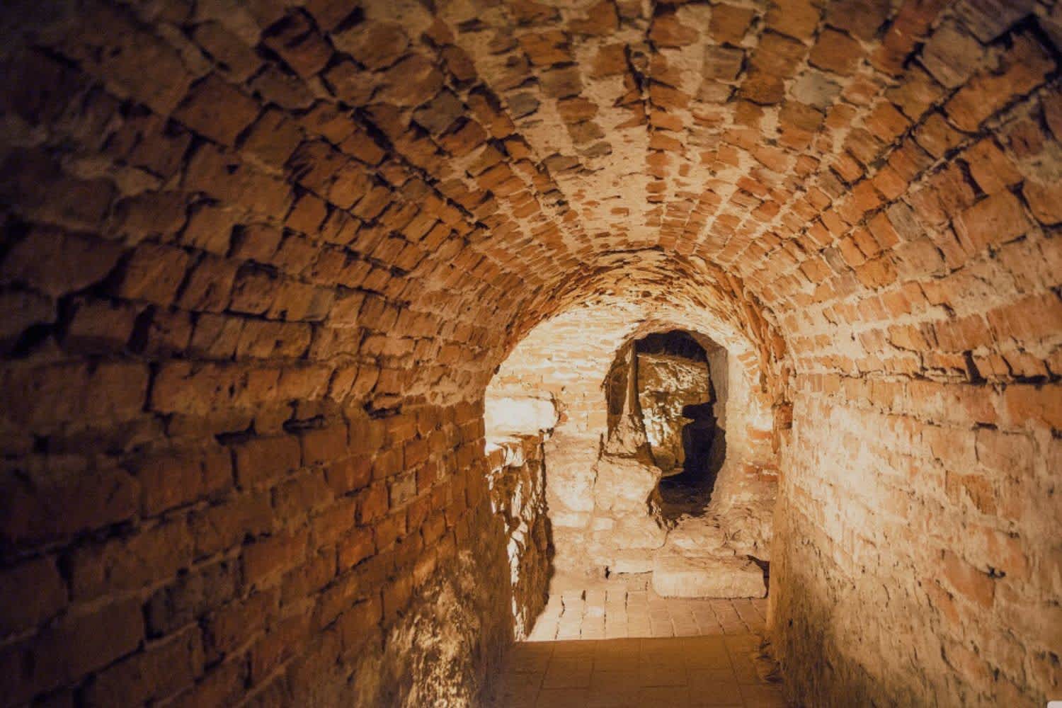 A historic brick tunnel within the Lviv underground catacombs illuminated by soft lighting