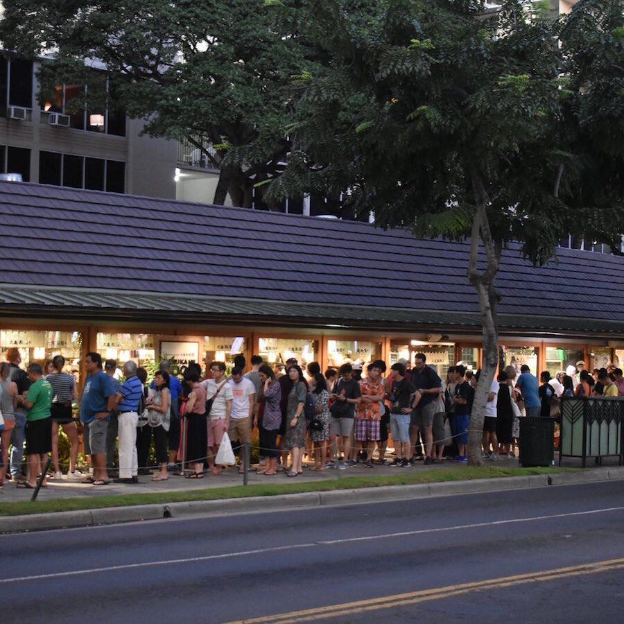 Long line of tourists waiting outside Marugame Udon in Waikiki, illustrating typical long restaurant wait times in popular Hawaii spots