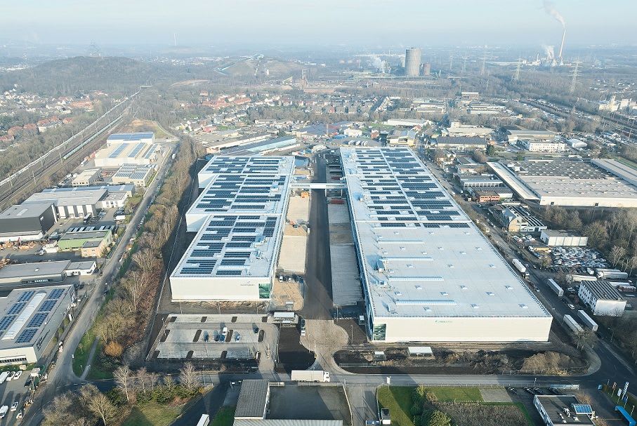 Aerial view of a modern logistics center in Germany featuring large warehouse buildings with solar panels on the roofs