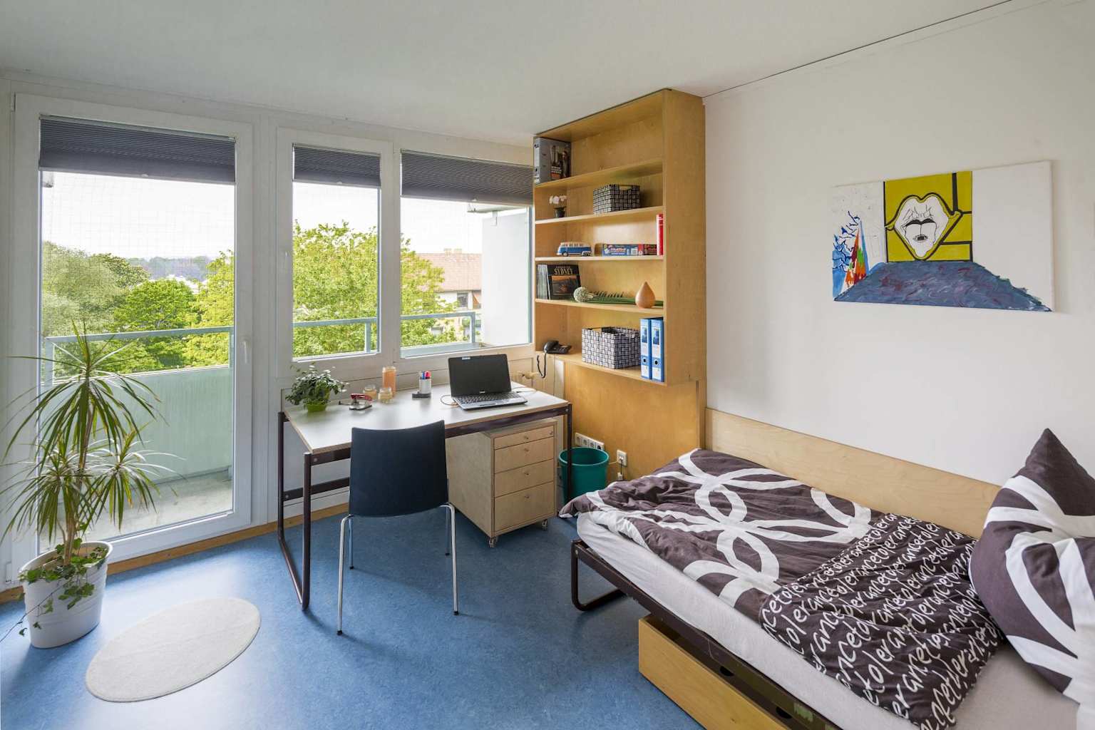 Modern student apartment room in Germany with functional study area and natural light