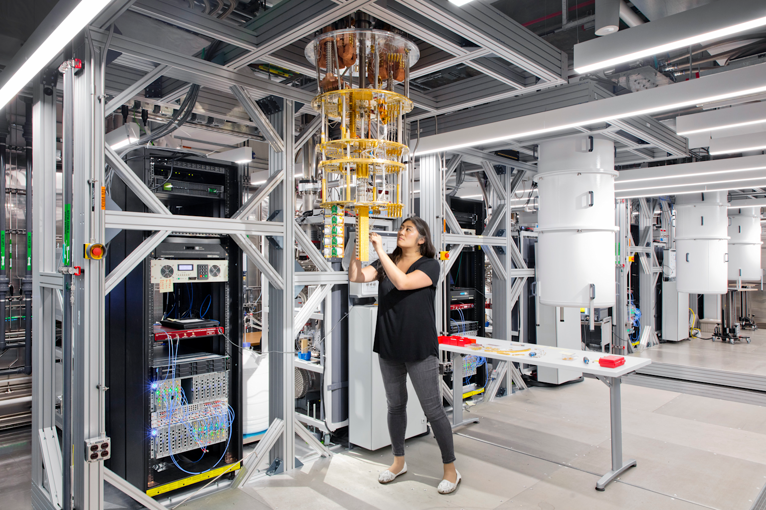 A view inside an IBM quantum computing laboratory showing a quantum processor in a dilution refrigerator and associated hardware