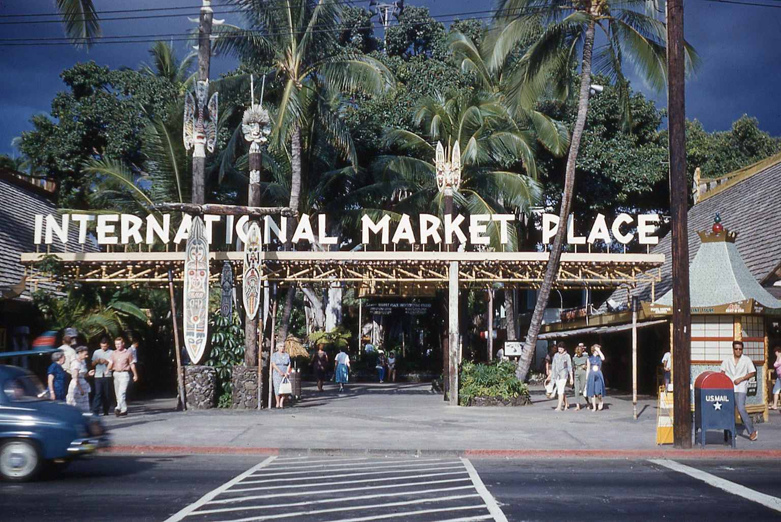 Vintage 1960s photo of the entrance to the International Market Place in Waikiki, showcasing its tropical Hawaiian theme and bustling market scene