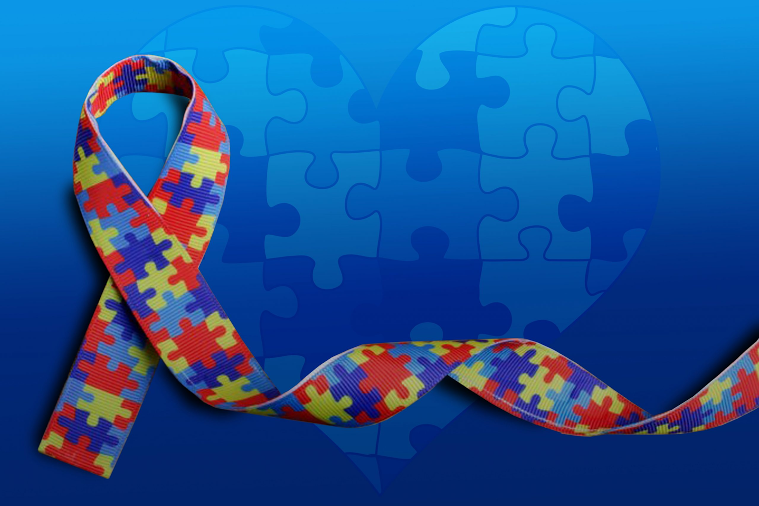 Autism awareness ribbon with puzzle piece pattern and blue puzzle heart symbol