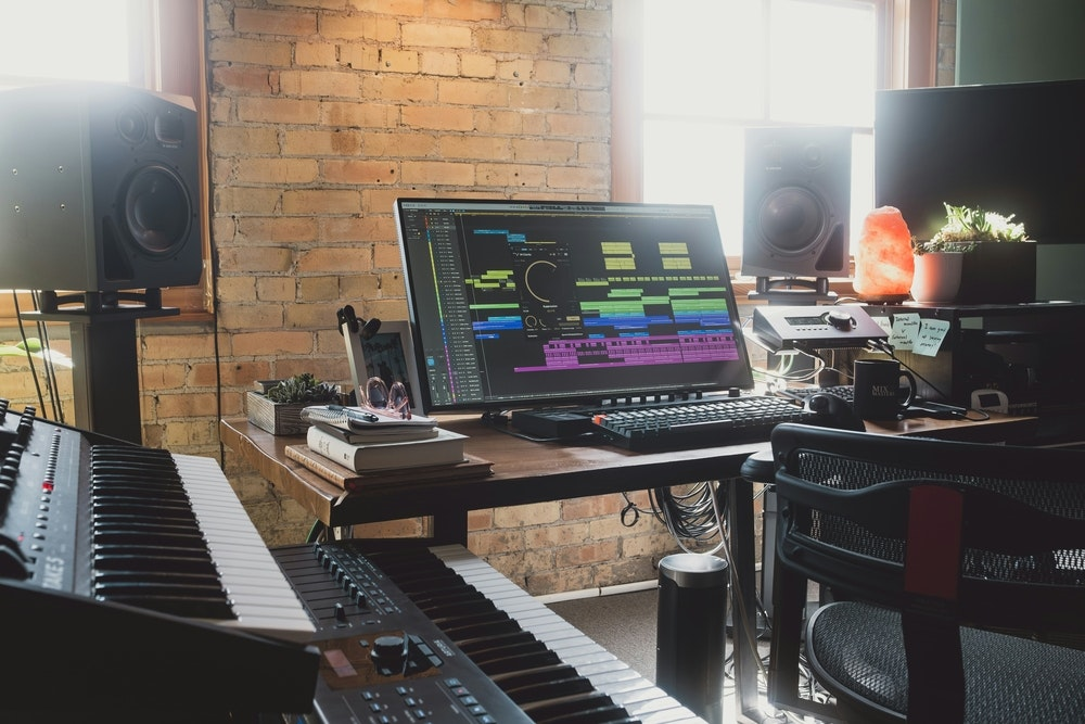Modern music production studio with digital audio workstation and MIDI keyboards showcasing an AI-enhanced creative environment