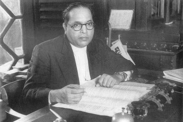 Dr. B. R. Ambedkar reading and studying at his desk, reflecting his deep engagement with knowledge and intellectual pursuits