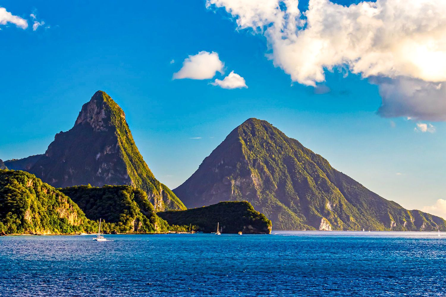 The Pitons: iconic volcanic mountains in St. Lucia's Caribbean landscape with sailboats on the water