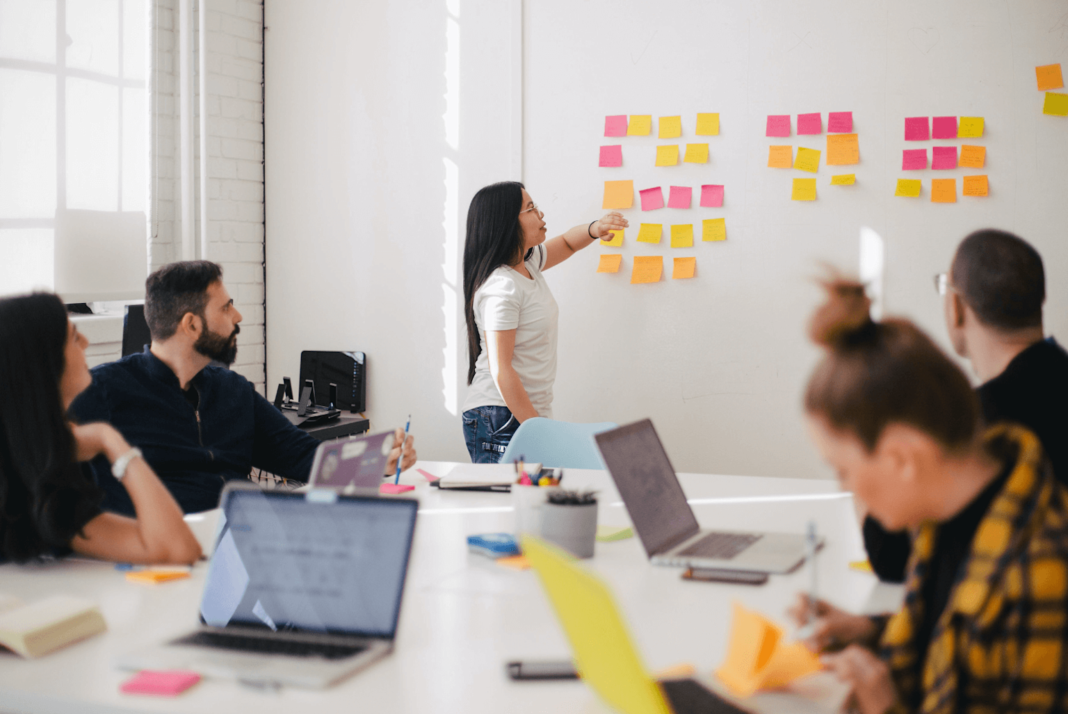 Team brainstorming using sticky notes to organize ideas in a collaborative office meeting
