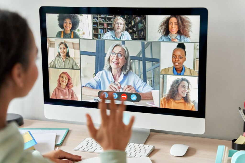 A professional engages in a virtual video call with a diverse remote team, illustrating remote collaboration and communication