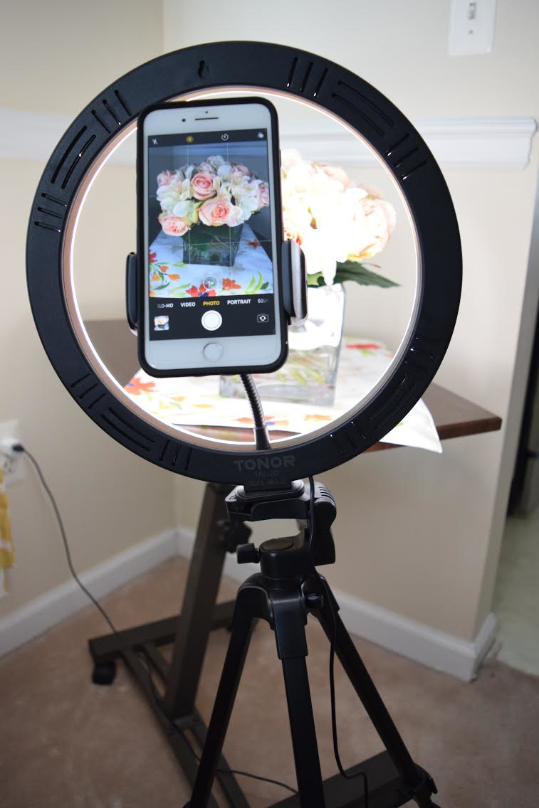 Smartphone mounted on tripod with ring light for professional-quality product photography lighting.