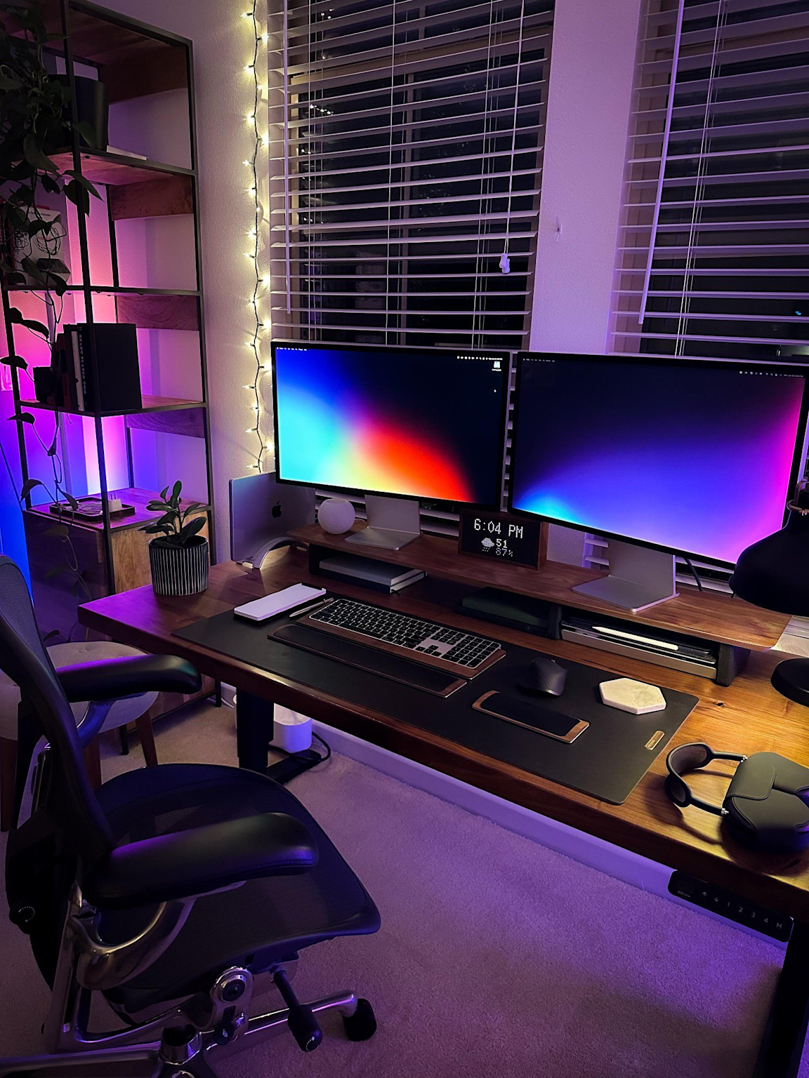 A modern remote developer's home workspace with dual monitors, ergonomic setup, and ambient lighting