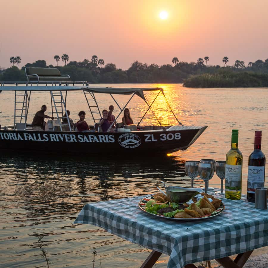 Sunset river safari in Livingstone, Zambia, with a boat cruise and riverside dining offering appetizers and wine