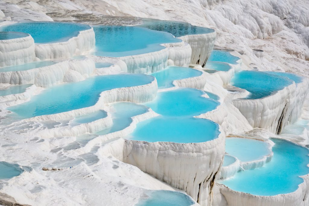Pamukkale's white terraces and turquoise thermal pools in Turkey, a site of historical and biblical significance near ancient Hierapolis