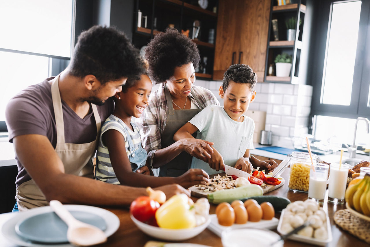 Family cooking a healthy meal together with fresh vegetables and balanced ingredients in a bright kitchen