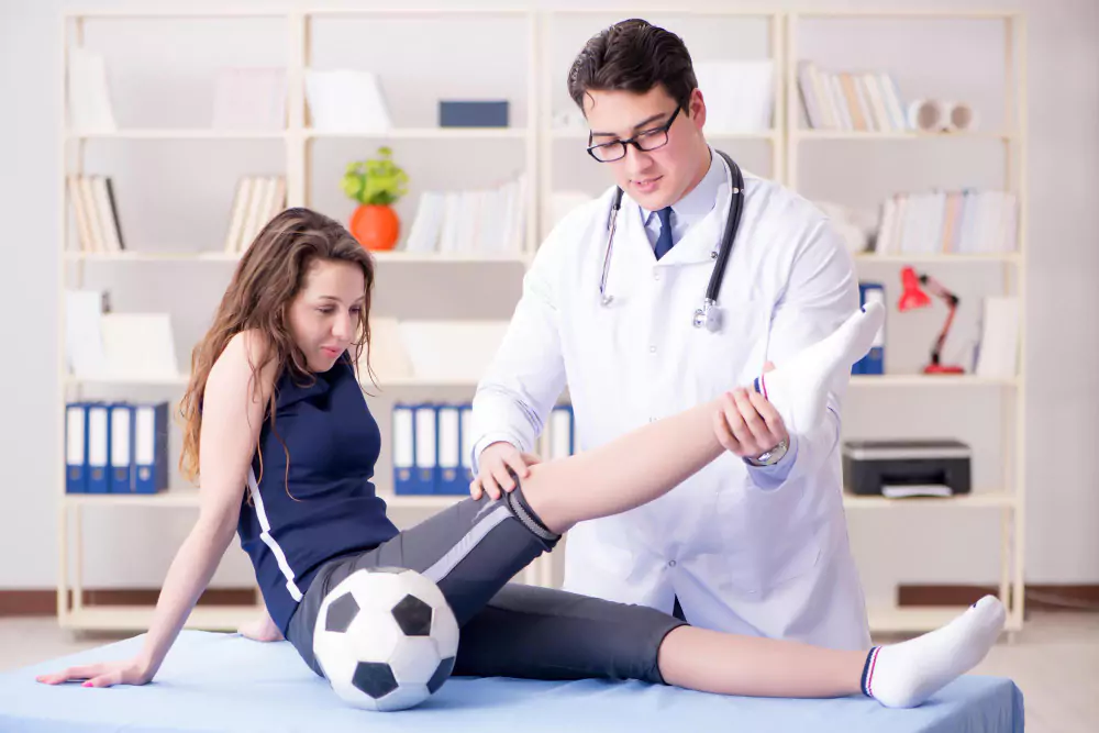 A doctor examines a female athlete's leg in a sports medicine setting, highlighting injury assessment and care