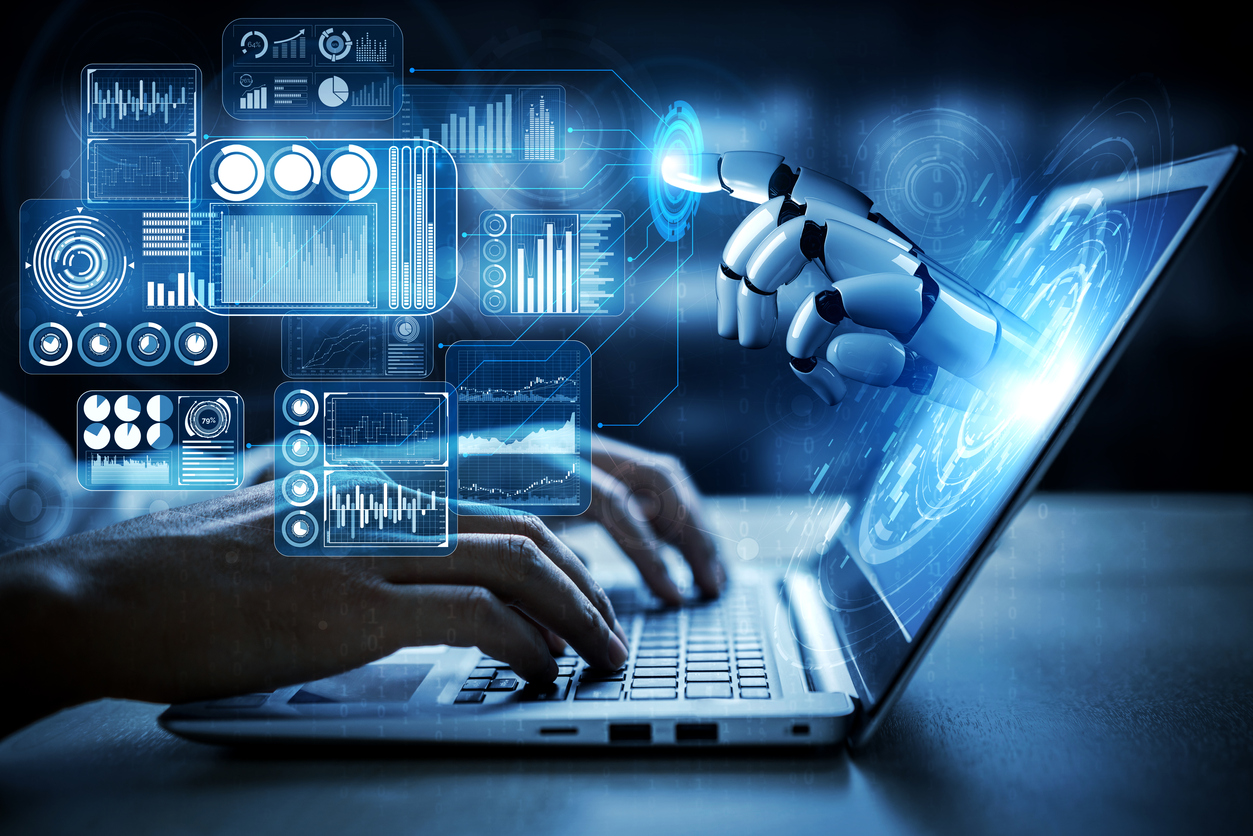 Human hands typing on a laptop with a robotic hand emerging from the screen, symbolizing the interaction between humans and artificial intelligence in education