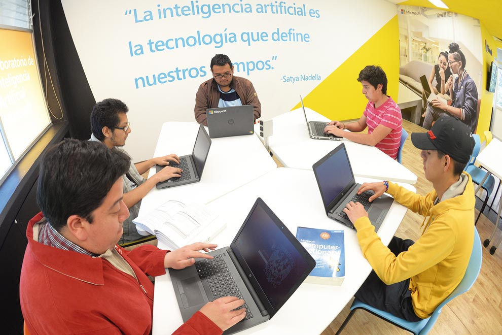 Students working with laptops in a Mexican AI laboratory featuring a quote emphasizing the importance of artificial intelligence in modern times