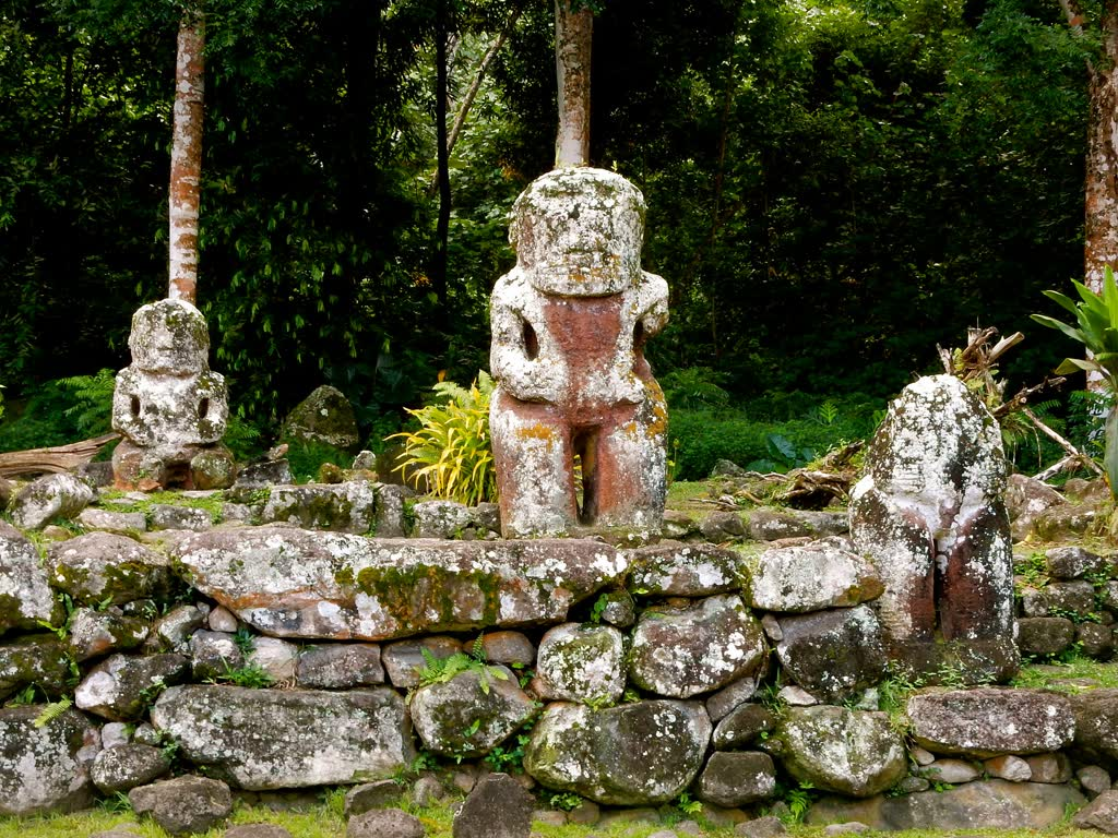 Ancient Polynesian tiki statues at an archaeological site in the Marquesas Islands, symbolizing the rich cultural heritage of the region