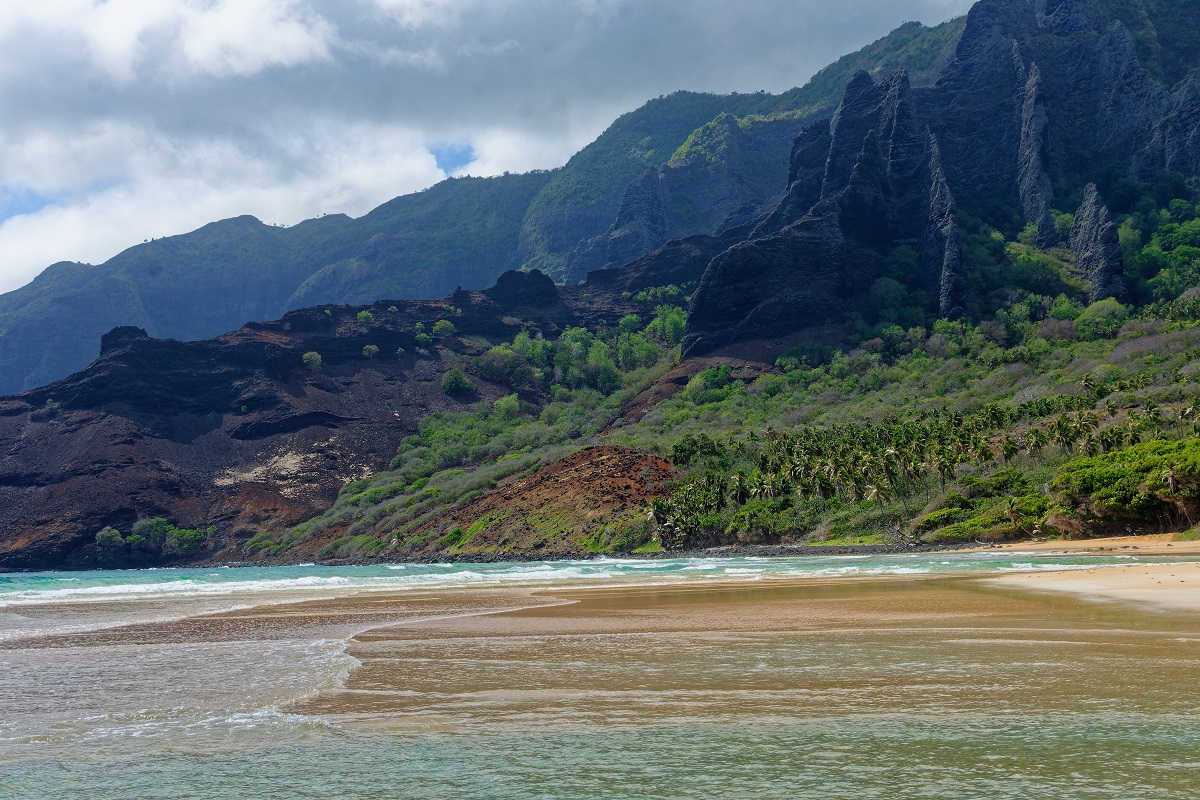 Hatiheu Bay on Nuku Hiva island features rugged volcanic cliffs and a pristine beach, exemplifying the Marquesas Islands' unique and adventurous landscape